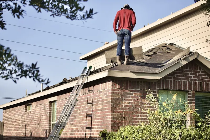 Professional roofer working on a residential roof in Village of Fairfield